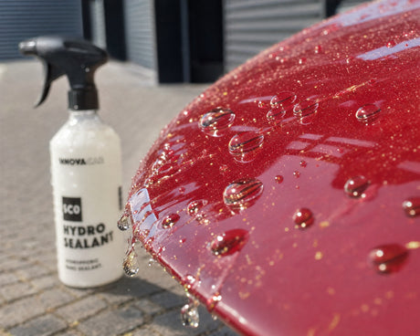 Wasser perlt nach der Versiegelung mit INNOVACAR SC0 Hydro Sealant vom roten Audi-Lack ab