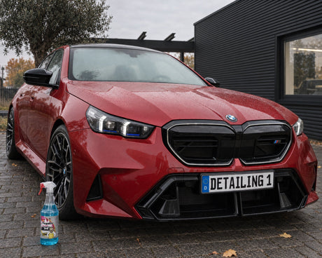 Tugalin Glas-Teufel voor een rode BMW M5 met beslagen voorruit — te zien in het artikel „Auto beslaat van binnen: waarom een schone ruit langer helder blijft”