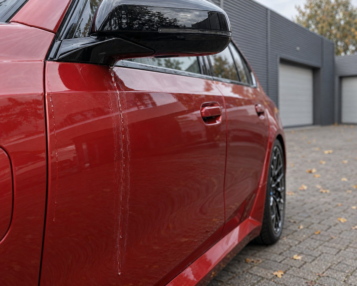 Detailing1 Sécher sa voiture — l'eau qui coule du rétro trace des auréoles de calcaire sur la porte d'une BMW M5 rouge