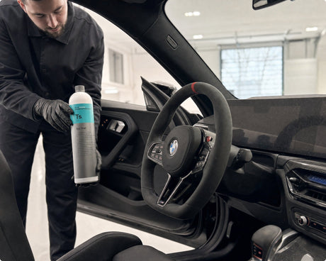 Detailing1 Koch-Chemie Top Star Ts — Daniel mit der Innenraum-Kunststoffpflege am offenen Cockpit eines schwarzen BMW M2