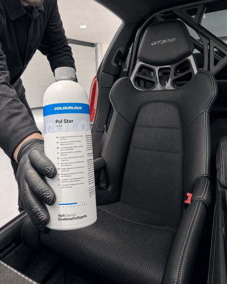 COLOURLOCK Pol Star in Daniels Hand vor dem fertig gereinigten schwarzen Ledersitz des roten Porsche 911 GT3 RS.