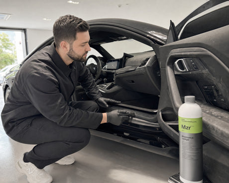 Detailing1 Koch-Chemie Mzr — verstaubtes Cockpit eines schwarzen BMW M2 vor der Innenraumreinigung