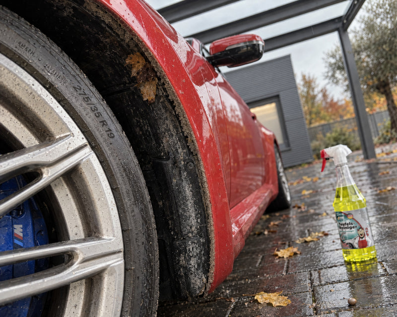 TUGA Chemie Teufels-Reiniger à côté du passage de roue d'une BMW M2, avec un liseré de crasse gris sur le bord serti