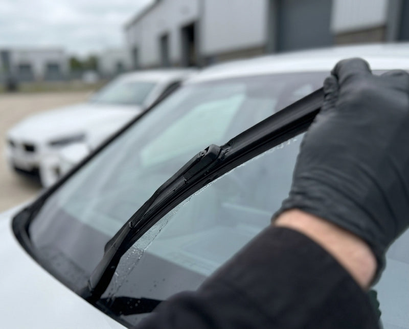 Detailing1 saubere Wischerlippe zieht streifenfrei ueber die klare Frontscheibe des weissen BMW M2