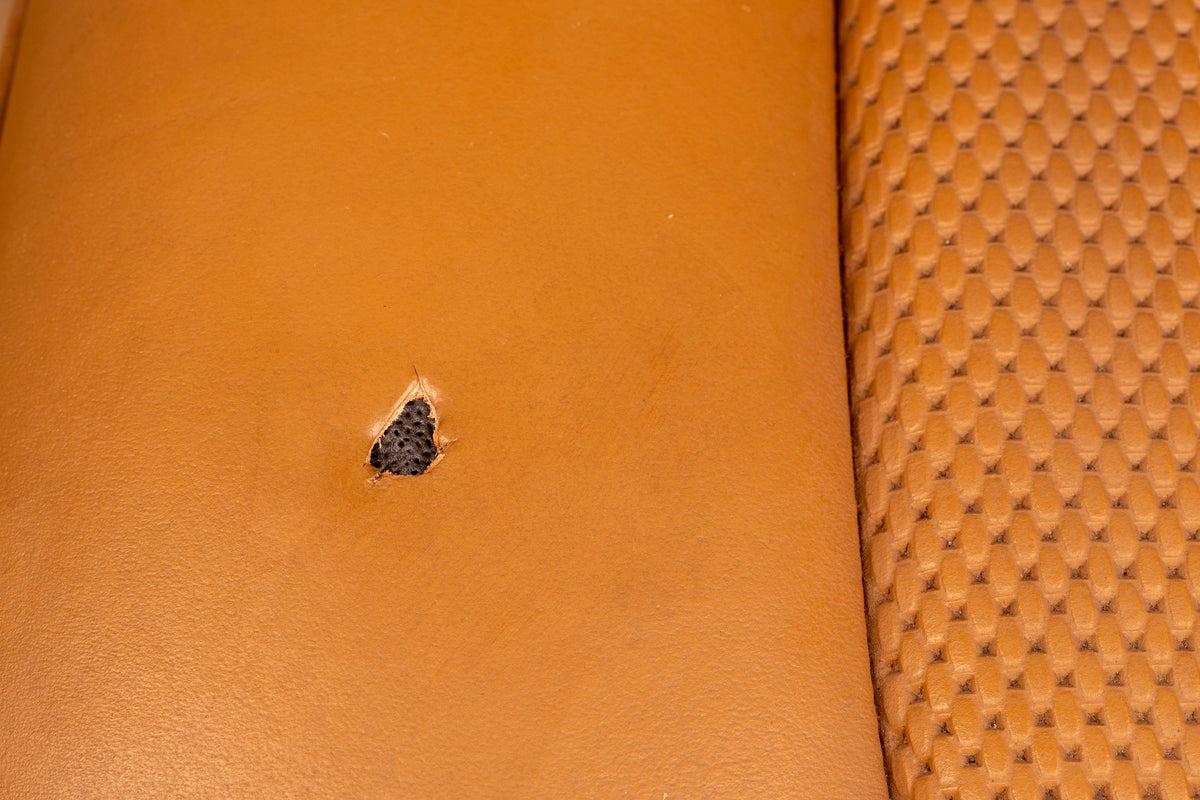 Detailing1 COLOURLOCK Fluid Leather — brandgaatje in een cognackleurige, geperforeerde leren stoel
