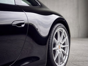 Saubere schwarze Porsche 911 Heckflanke nach der Behandlung mit streifenfreier Silberfelge ohne Flugrost-Punkte